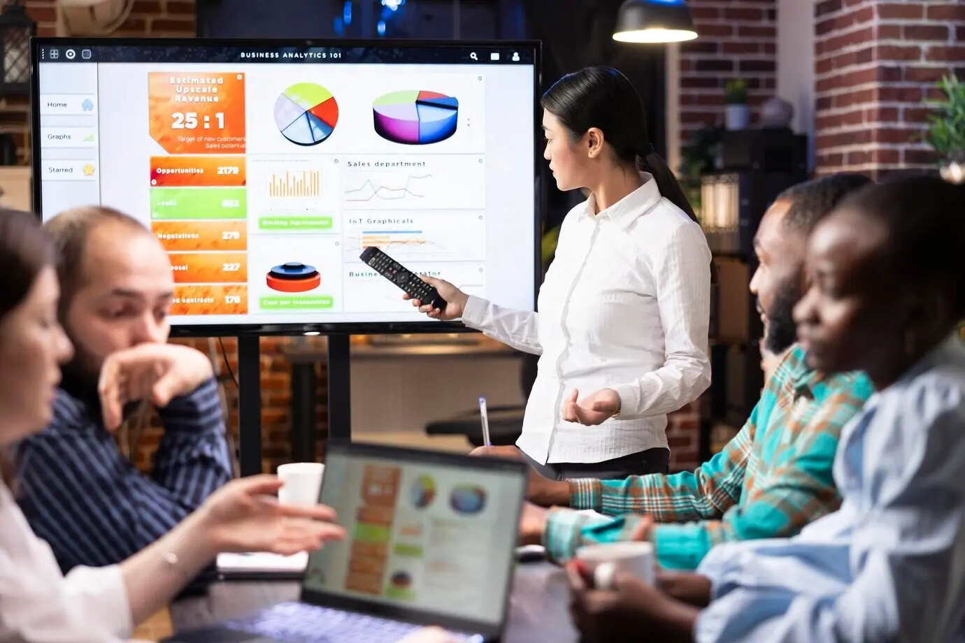 Азиатский менеджер обсуждает с командой бизнес-аналитику.