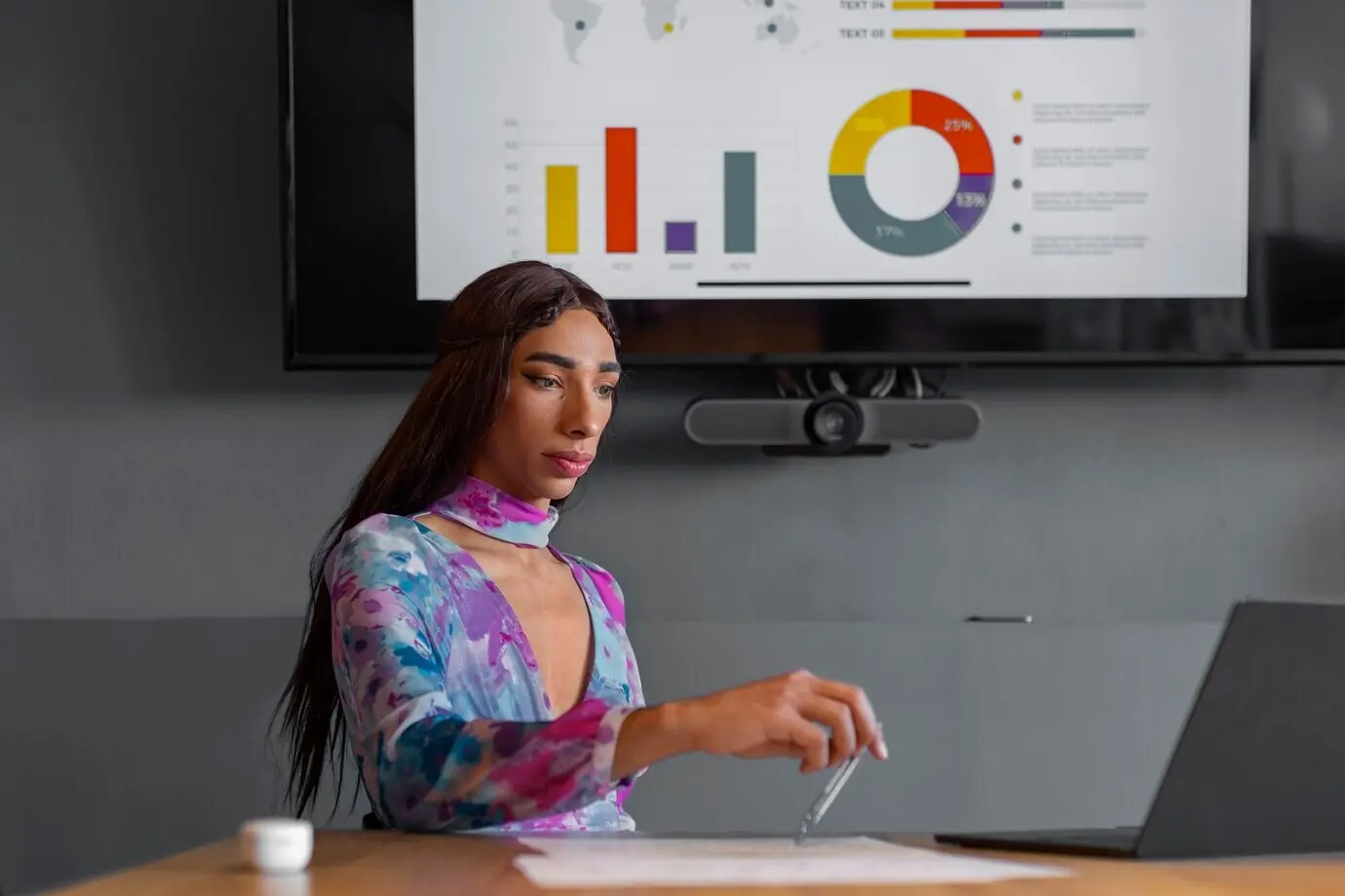 Средний план квир-модели, работающей за ноутбуком.