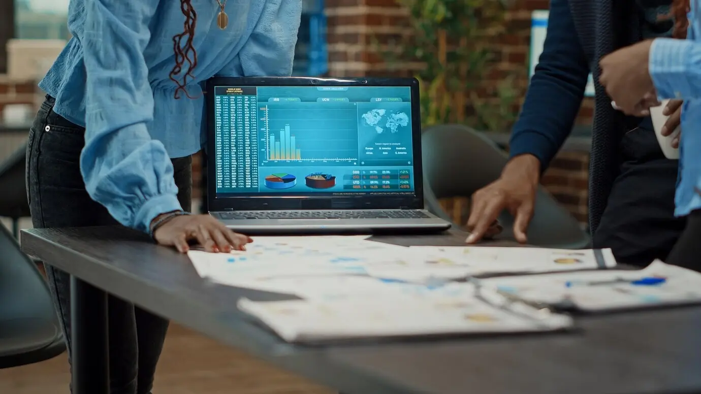 Коллеги изучают отчёты на бумаге, рассматривают статистику и ежегодную аналитику данных для повышения прибыли. Группа сотрудников планирует исследовательскую стратегию, используя документы для развития бизнеса.